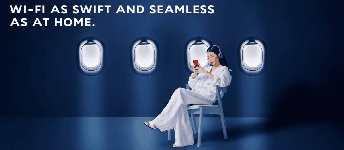 A passenger seated in an airplane cabin using her phone highlights the message 'Wi-Fi as swift and seamless as at home,' promoting the reliability and speed of in-flight internet. This imagery underscores the airline's commitment to providing a seamless connectivity experience for travelers.