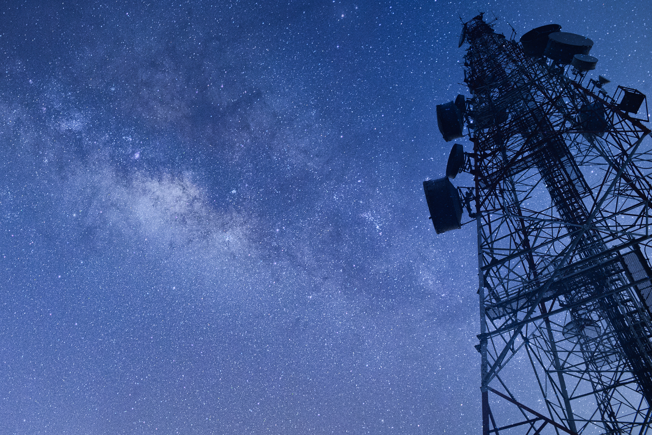 A towering telecommunications antenna set against a star-filled night sky, symbolizing global connectivity and satellite communication.