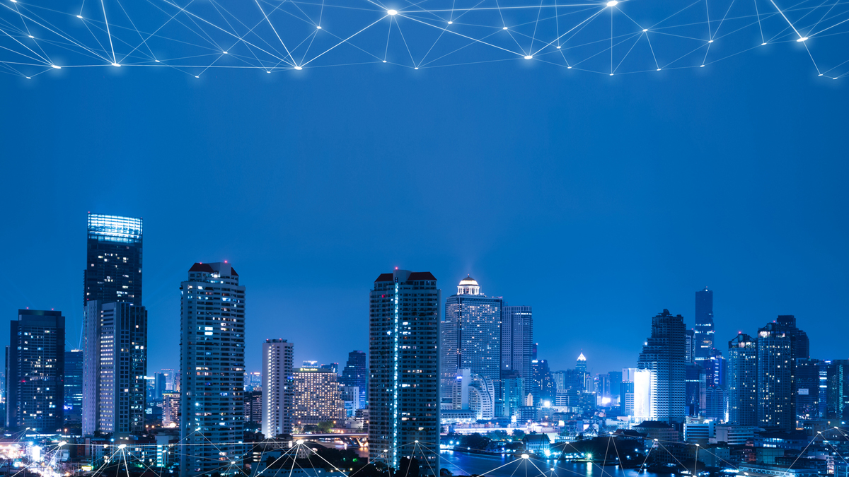 A digitally enhanced city skyline at night with an overlay of glowing network connections representing smart city technology and global connectivity.